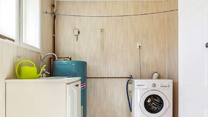 A laundry room with a washing machine, a water heater, and a radiator. - 4 Person Holiday Home in Motala (Motala)