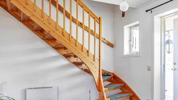 A wooden staircase with blue carpeted steps leading to a landing.