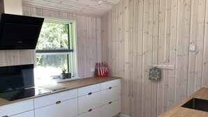A kitchen with a wooden countertop, white cabinets, and a window. - 8 Person Holiday Home in Hals (Hals)
