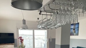 Una sala de estar moderna con comedor, un amplio ventanal con vistas y una araña.
