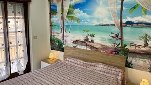 Quarto com um grande mural de uma cena de praia, estrutura de cama de madeira e mesa de cabeceira com abajur.