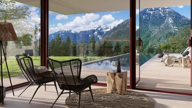 A modern room with large glass doors, a pool, and a mountain view. - Apartment With Shared Infinity Pool (Sankt Martin am Tennengebirge)