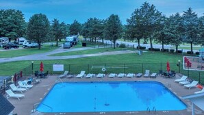 A swimming pool with lounge chairs and a fenced area with trees. - Rustic Cabin in Bloomington with Views (Bloomington)