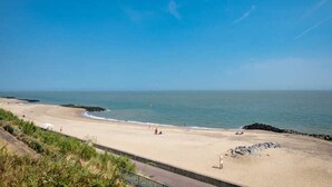 A beach with a clear sky, calm sea, and a sandy shore. - Apartment on the 2nd Floor for Family (Middelkerke)
