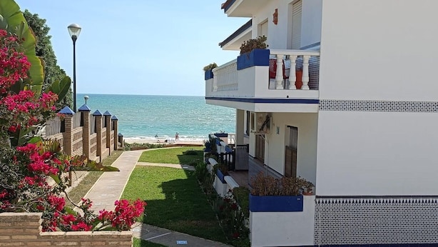 Un immeuble de deux étages doté d’un balcon donnant sur une plage.