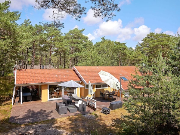 A house with a red-tiled roof, a patio with outdoor furniture, and a satellite dish.