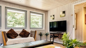 Una sala de estar con sofá, televisor y mesa de centro.