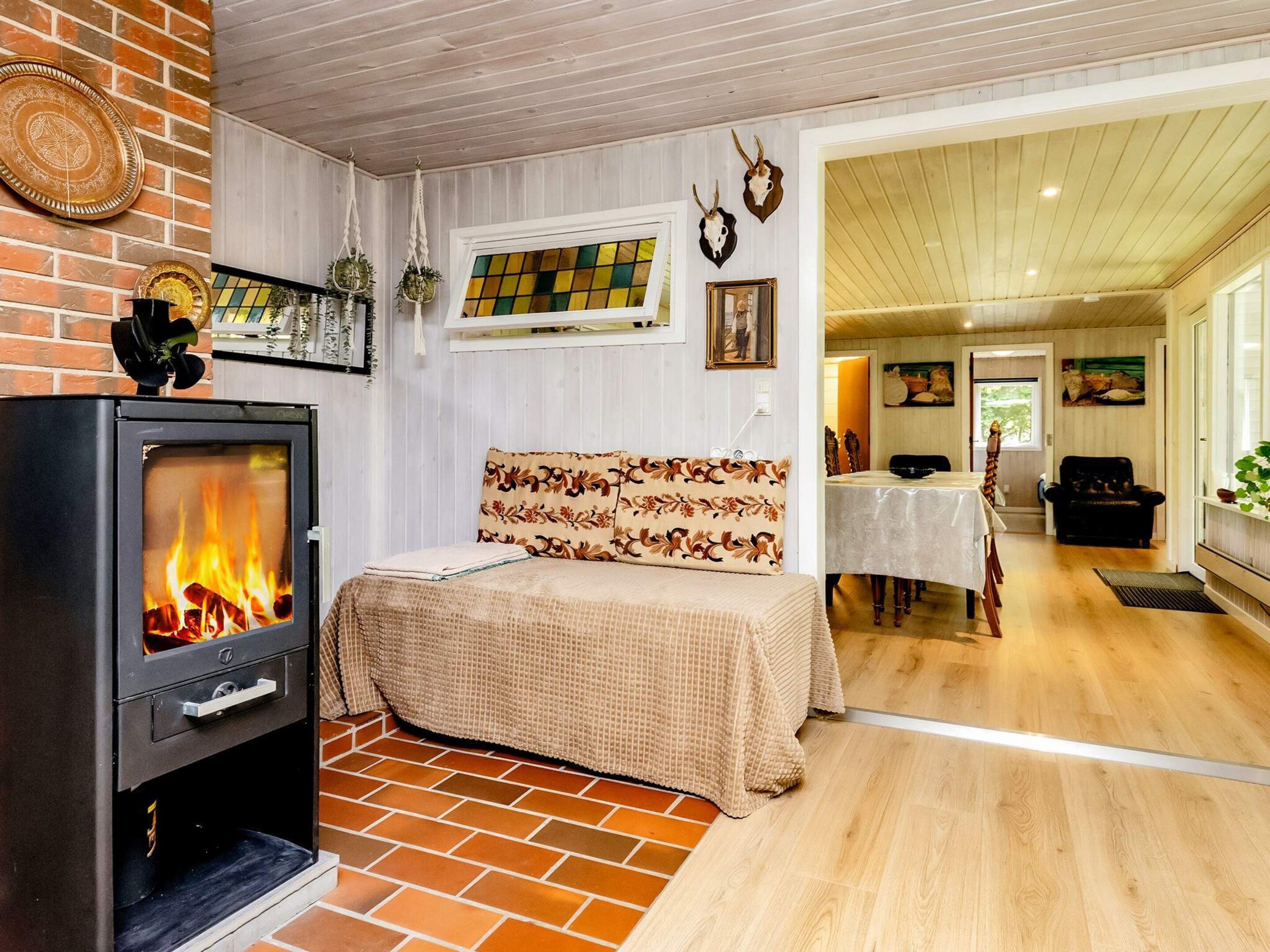 A cozy room with a fireplace, a bed with floral bedding, and a dining area with a table and chairs.