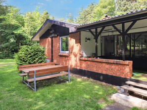A small brick building with a window and a bench in front. - 8 Person Holiday Home in Hadsund (Hadsund)