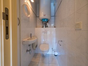 A compact bathroom with a toilet, sink, and a wall-mounted bidet. - Apartment on the Third Floor (Middelkerke)