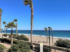 A beach with palm trees, a clear blue sky, and the ocean. - Belvilla by OYO Apartamento Moja!car (Mojacar)