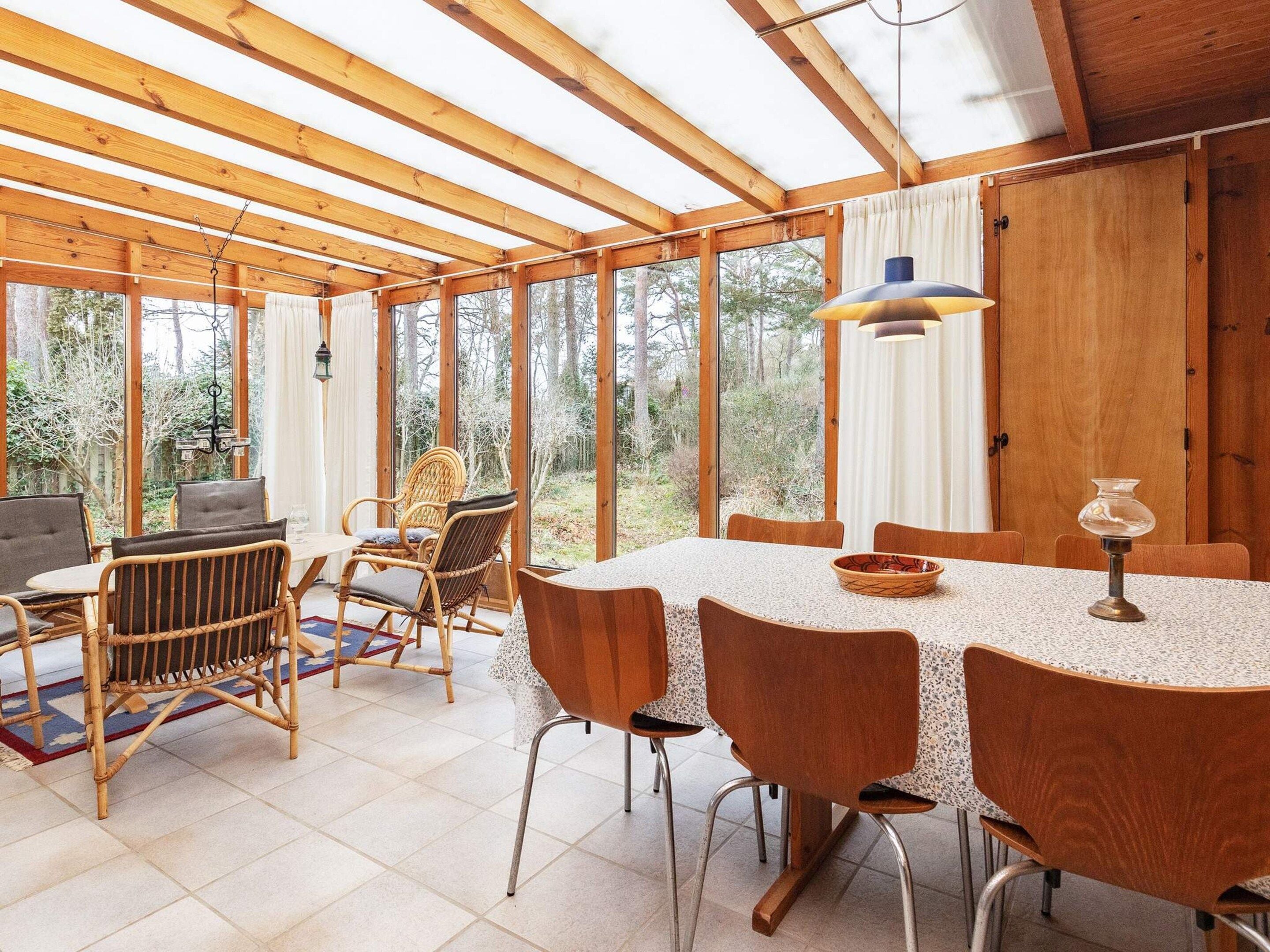 A dining area with a large table, chairs, and a view of the outdoors.