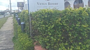 A sign for Venus Resort with a logo, name, and location. - Venus Resort (Long Jetty)