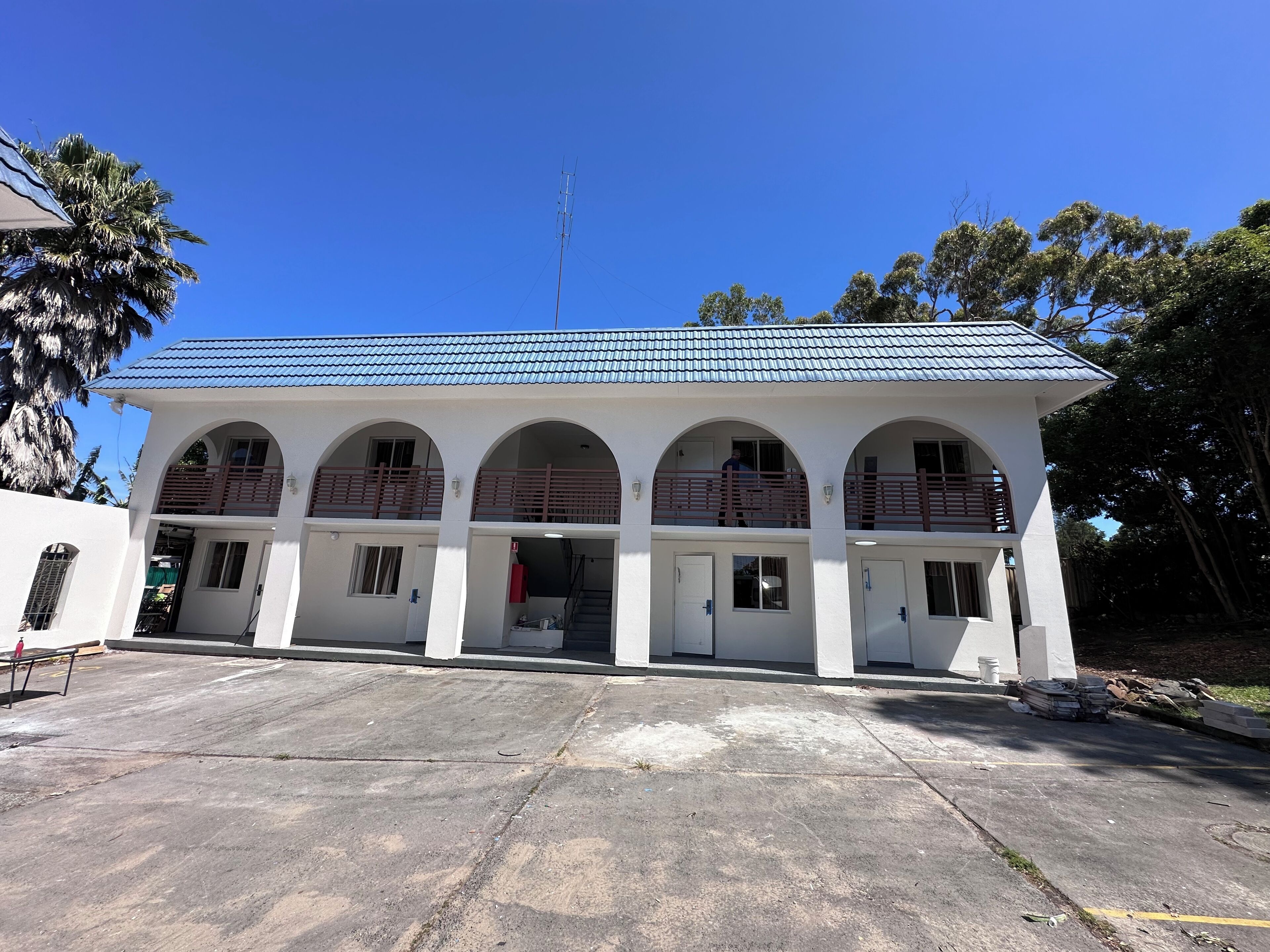 A two-story building with a flat roof and arched windows.