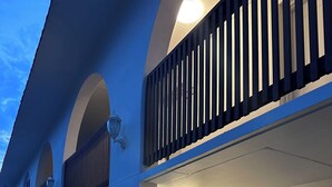 A hotel with a series of rooms arranged in a row, each with a door and a small window. - Venus Resort (Long Jetty)