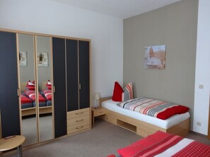 A bedroom with a bed, a wardrobe, a desk, and a chair. - 2 am Lustgarten Modern Retreat (Wernigerode)