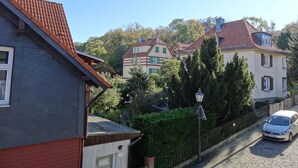 A residential street with houses, a cobblestone road, and a parked car. - 2 am Lustgarten Modern Retreat (Wernigerode)