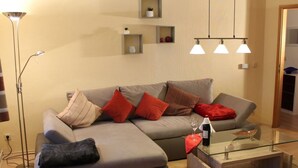 A modern living room with a grey sectional sofa, a glass coffee table, and a floor lamp. - 2 am Lustgarten Modern Retreat (Wernigerode)