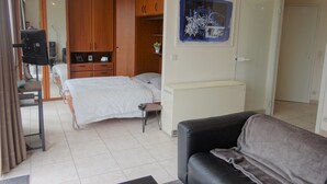 A bedroom with a bed, a wardrobe, a desk, and a black leather sofa. - Apartment in Nieuwpoort for 4 Persons (Nieuwpoort)