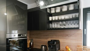 Una cocina moderna con horno empotrado, cafetera y encimera de madera.