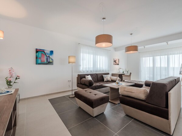 A modern living room with a sofa set, a coffee table, and a floor lamp. - Apartment in Croatia by the Adriatic Coast (Sukosan)
