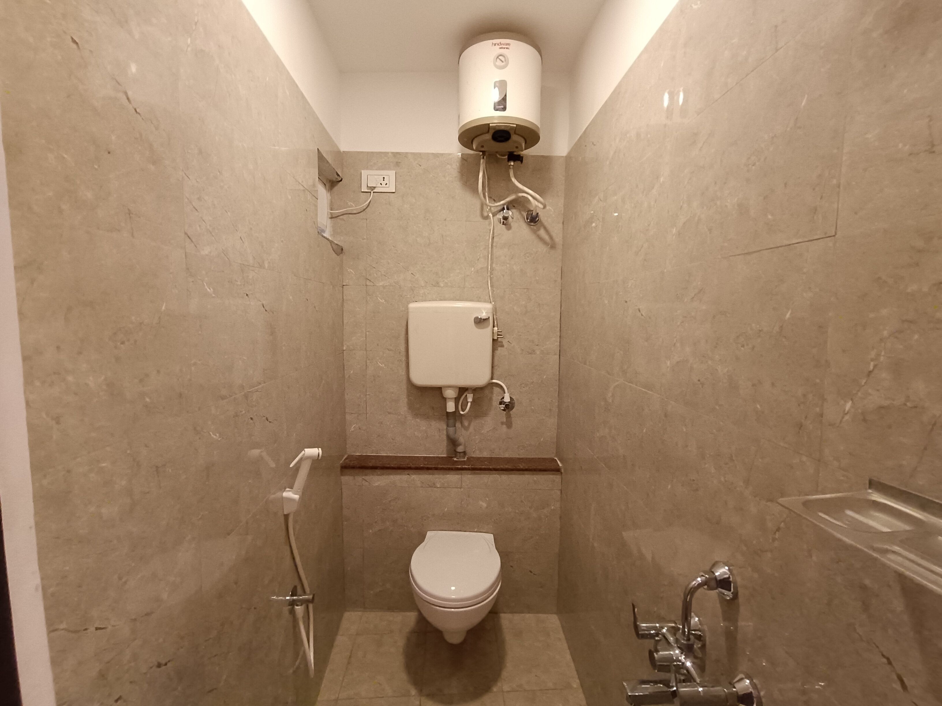 A small, modern bathroom with a toilet, a shower, and a sink.