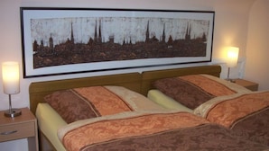 Ein Hotelzimmer mit einem großen Bett, zwei Nachttischen und einem gerahmten Bild an der Wand.