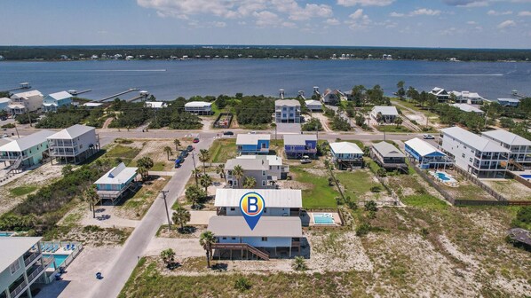 Une zone résidentielle côtière comprenant des maisons, une plage et une vaste étendue d’eau.