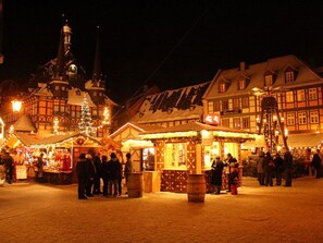 A traditional European market square at night with historic buildings, stalls, and a prominent church tower. - Am Lustgarten Modern Retreat (Wernigerode)
