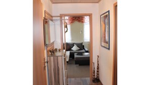 A hallway leading to a living area with a sofa, a glass table, and a giraffe figurine. - Am Lustgarten Modern Retreat (Wernigerode)