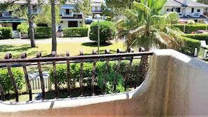 Un quartier résidentiel doté d’un chemin pavé, d’une rambarde en métal et d’un espace vert bien entretenu, comprenant des arbres et des arbustes.