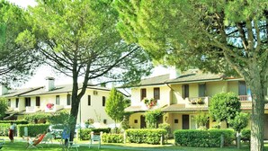 Un immeuble résidentiel doté de nombreux balcons, d’une pelouse bien entretenue et d’un chemin clairement délimité.