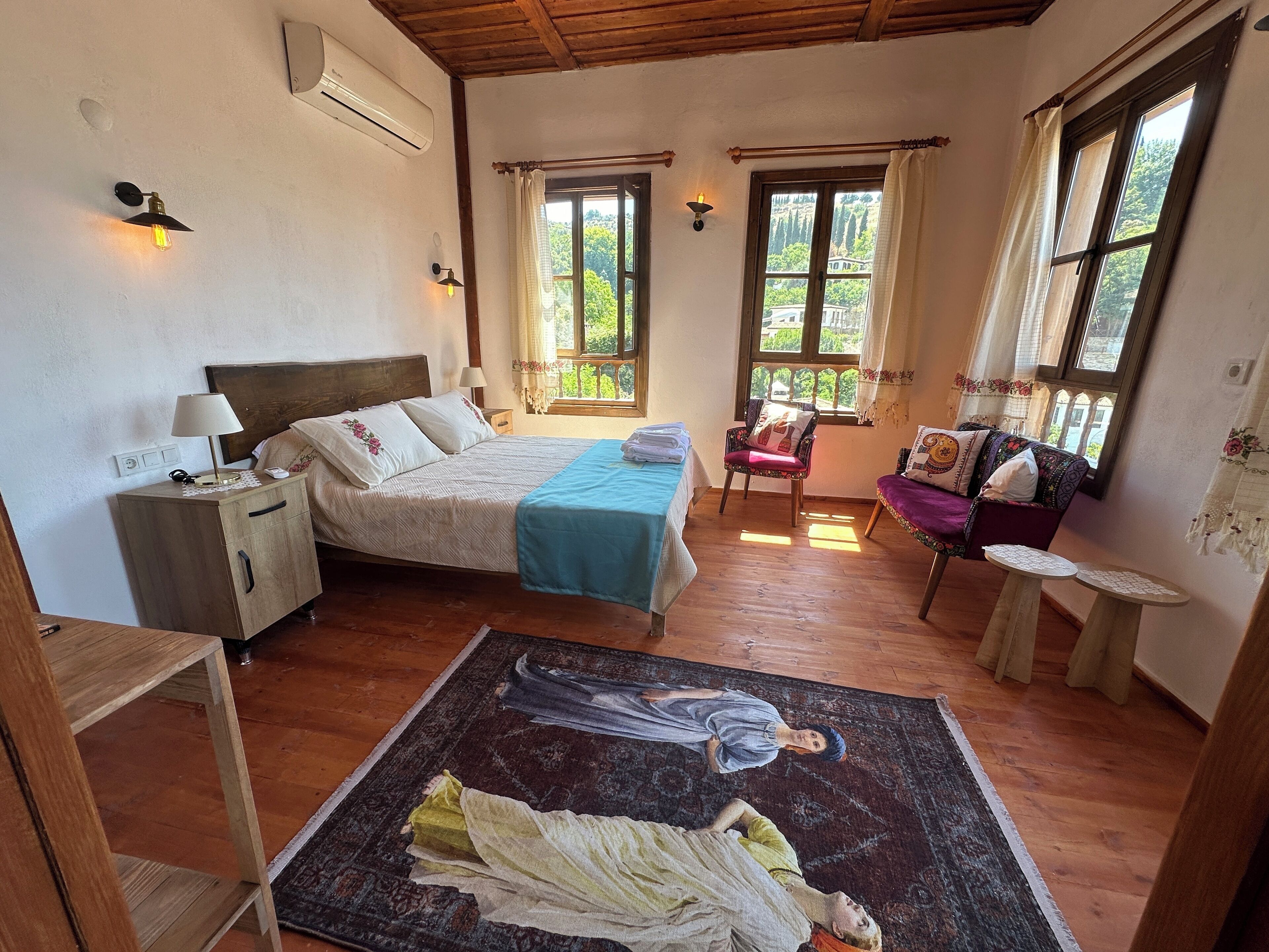 Une chambre à coucher comprenant un lit, une table de chevet, une chaise et une petite table avec une lampe.
