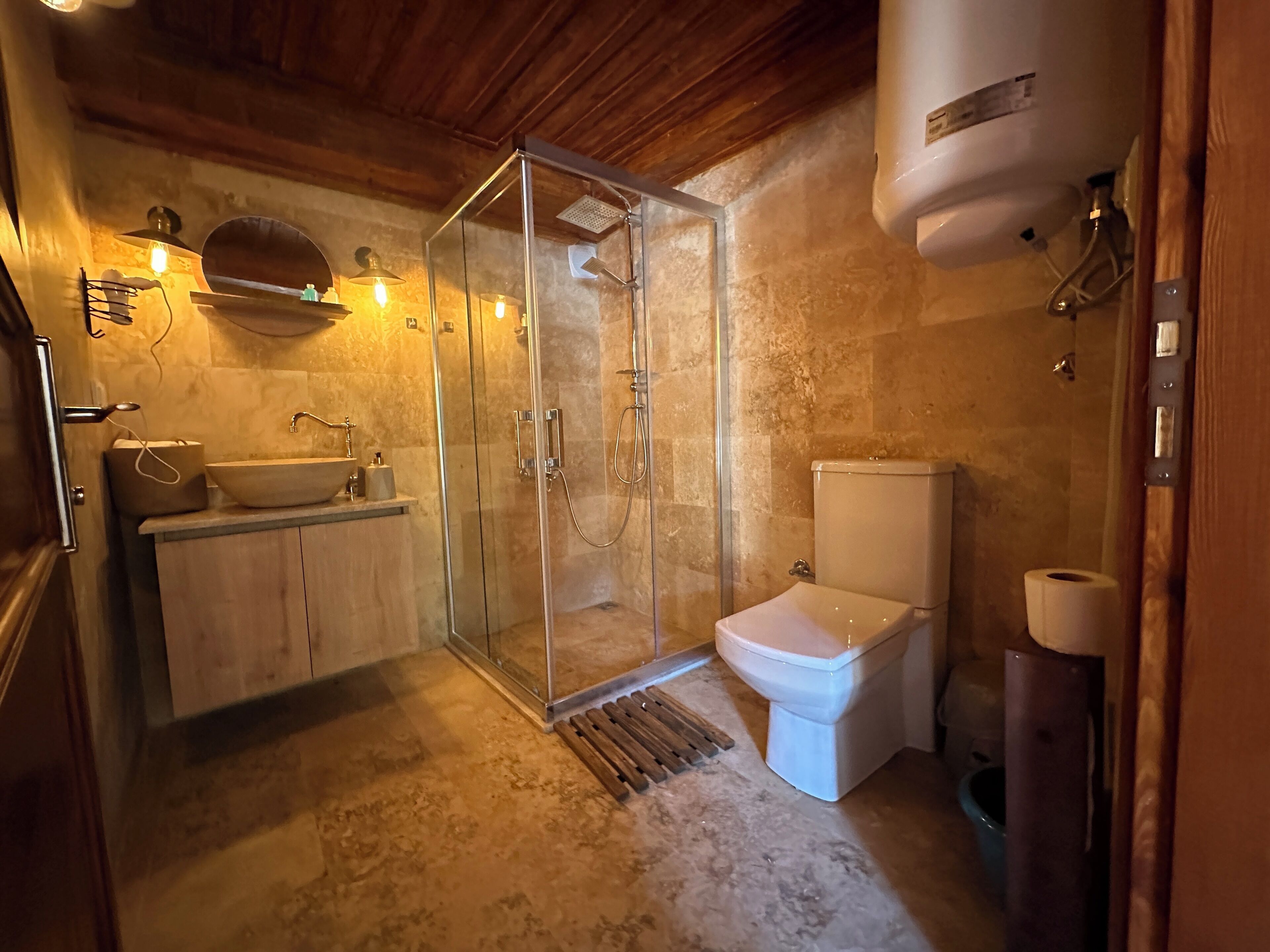 A bathroom with a glass-enclosed shower, a white sink, and a toilet.