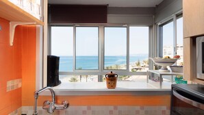 Una cocina con un ventanal grande con vista al mar, un fregadero y una estufa.