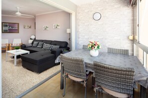 A living room with a sofa, ottoman, and dining table with chairs.