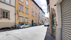 A narrow street with buildings on both sides, a parked car, and a bicycle. - Mansion in Lucca Near Via Fillungo (Lucca)