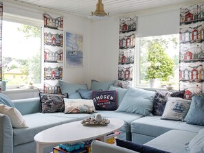 A cozy living room with a light blue sofa, a white coffee table, and a painting on the wall. - 4 Star Holiday Home in Brastad (Brastad)