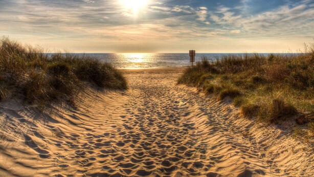 A sandy beach path leading to the ocean with a signpost in the distance. - Holiday Apartment Harbor Flair (Karlshagen)