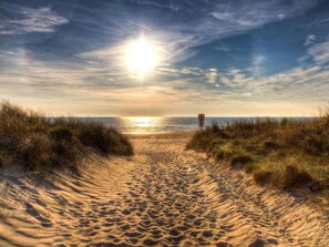 A sandy beach path leading to the ocean with a signpost in the distance. - Holiday Apartment Harbor Flair (Karlshagen)