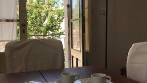 A dining table with two white cups and saucers, a magazine, and a woven placemat. - Cozy Apartment in Torrenova (Capri Leone)
