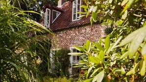 A brick house with a red roof, surrounded by lush greenery and a well-maintained garden. - Orangery Berum Modern Retreat (Hage)