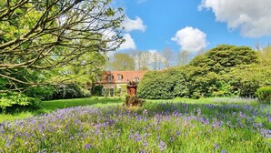 A large house surrounded by a lush garden with a field of purple flowers. - Orangery Berum Modern Retreat (Hage)