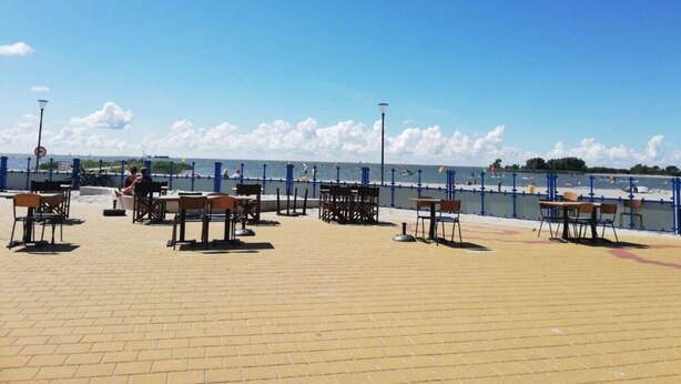 Un patio frente al mar con mobiliario exterior y vistas al océano.