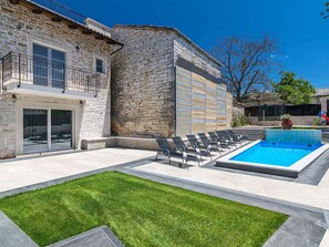 A stone house with a pool, outdoor seating, and a well-maintained lawn. - Villa Patrick Comfortable Holiday Residence (Pazin)