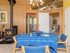A wooden interior with a dining table, chairs, a fireplace, and a kitchen area. - 6 Person Holiday Home in Fur (Fur)
