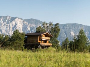A wooden chalet with a balcony, set against a mountainous backdrop. - Lovely Apartment in Sautens (Sautens)