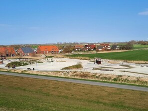 A rural landscape with houses, a sandy area, and a road. - Luetje Huuske Modern Retreat (Krummhoern)