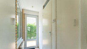 A narrow hallway with a sliding glass door leading to a balcony. - Holiday Home in Baarland With Garden (Baarland)