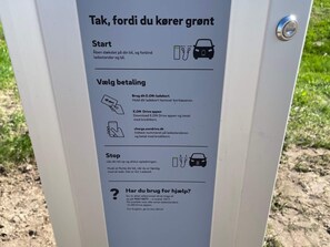 A charging station with instructions in Danish for starting and stopping the charging process, and for using the E.ON app. - Apartment in Holiday Park Near North Sea (Ulfborg)